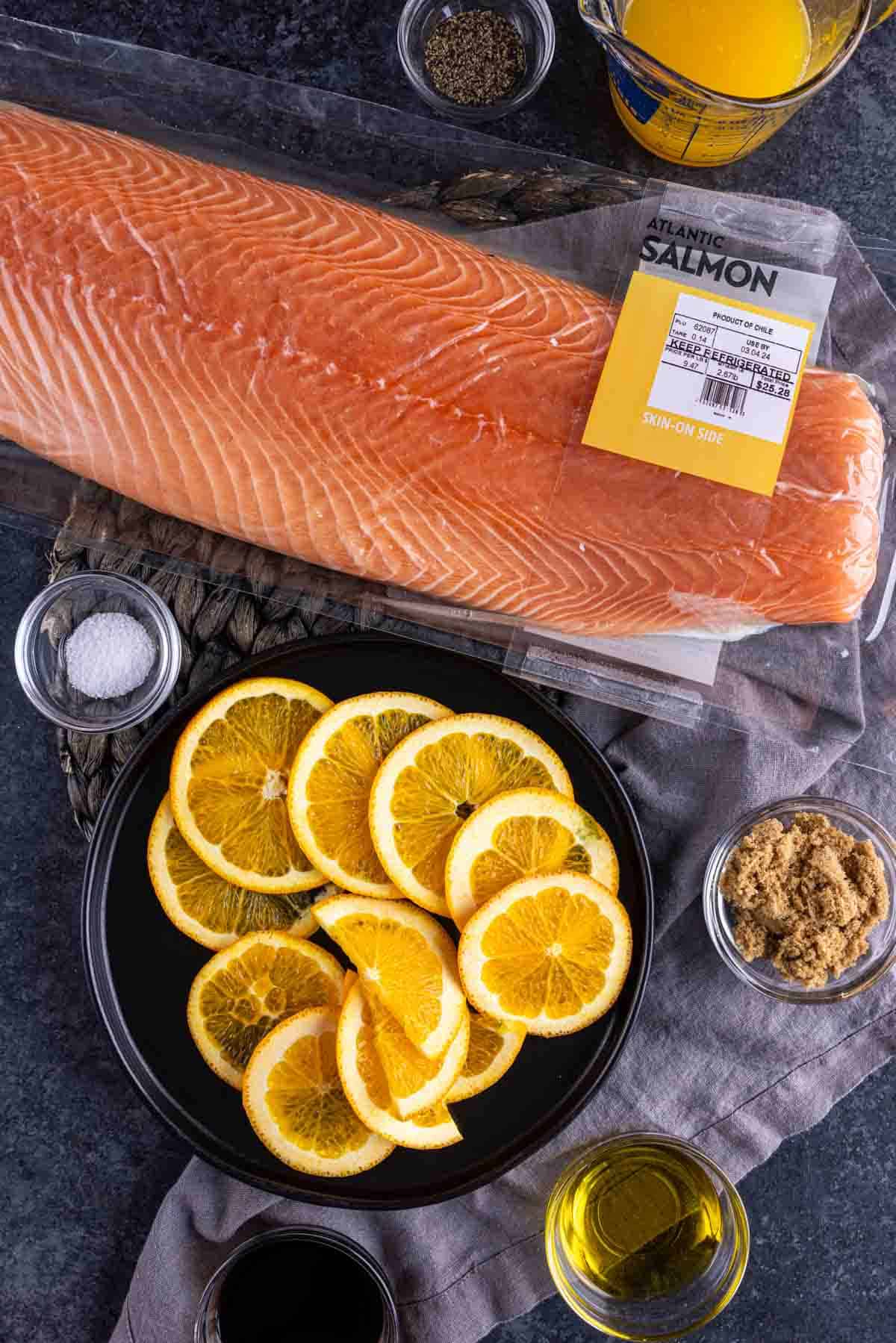 Fresh salmon fillet with orange slices and seasoning ingredients to make Orange Glazed Salmon