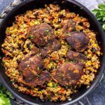 A skillet One pot mexican chicken and rice, vegetables, and black beans topped with four pieces of seasoned chicken.