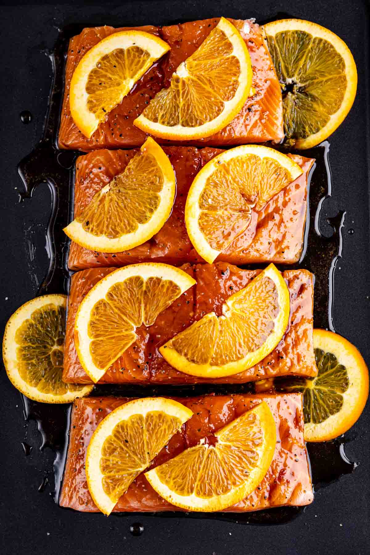 Orange-glazed salmon fillets ready for cooking.