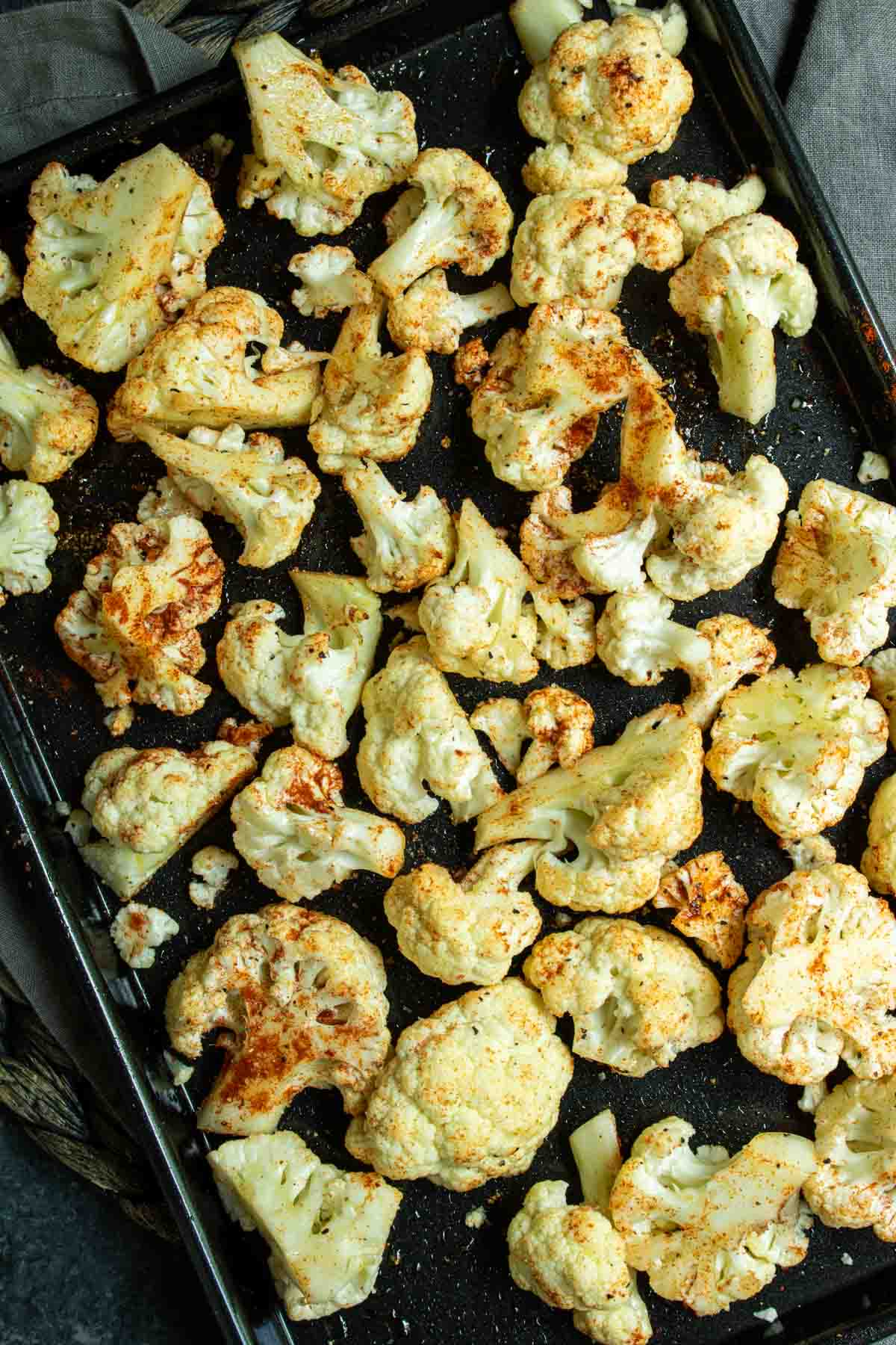 Roasted Cauliflower in the Air Fryer seasoned with spices on a baking sheet.