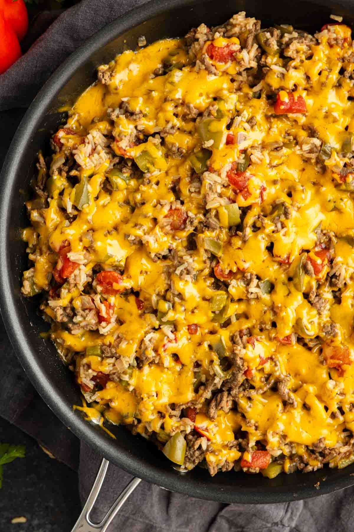 A delicious one pan unstuffed peppers dish, this skillet is filled with ground beef, rice, diced tomatoes, green peppers, and melted cheddar cheese.