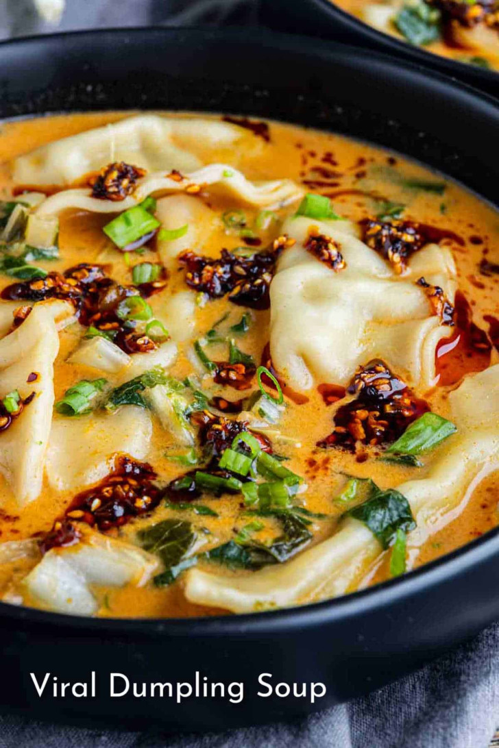 Bowl of soup with dumplings, chopped greens, scallions, and chili oil, labeled “Viral Dumpling Soup” at the bottom of the image.