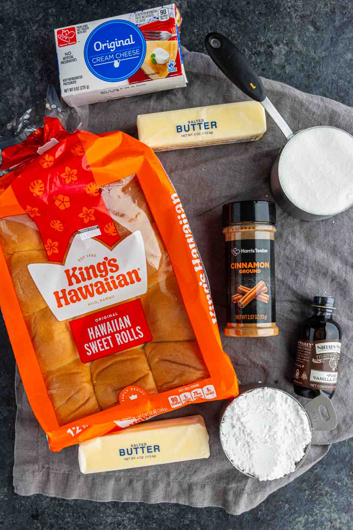 Ingredients for King’s Hawaiian cinnamon rolls, including a package of sweet rolls, two sticks of salted butter, cream cheese, granulated sugar, powdered sugar, ground cinnamon, and vanilla extract.