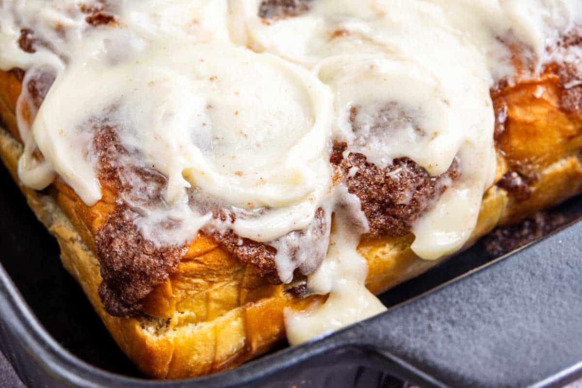 King’s Hawaiian cinnamon rolls topped with white icing in a baking dish.